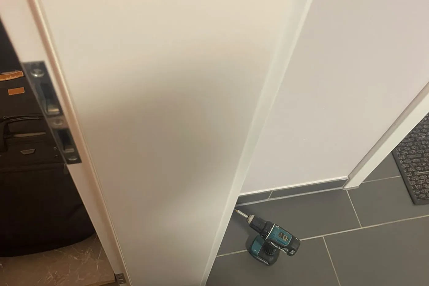 Geöffnete Wohnungstür, Werkzeugkoffer im Flur und Akkuschrauber auf dem Boden