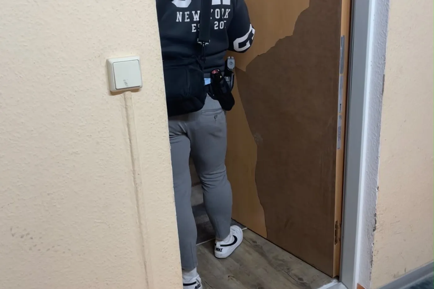 Geöffnete Wohnungstür nach einem Einsatz, Türblatt und Zarge beschädigt